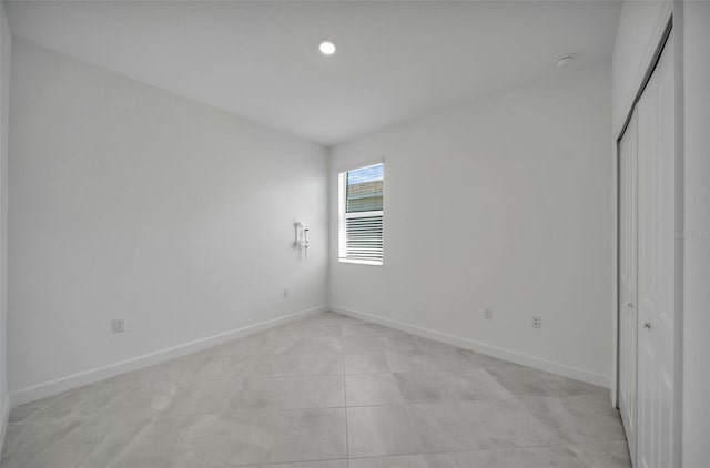 8589 Saint Kitts Cir, Englewood, FL 34224 - unfurnished bedroom featuring baseboards, a closet, light tile patterned flooring, and recessed lighting