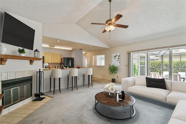 7035 Drury St, Tampa, FL 33635 - living area featuring a ceiling fan, light carpet, vaulted ceiling, a textured ceiling, and a tile fireplace