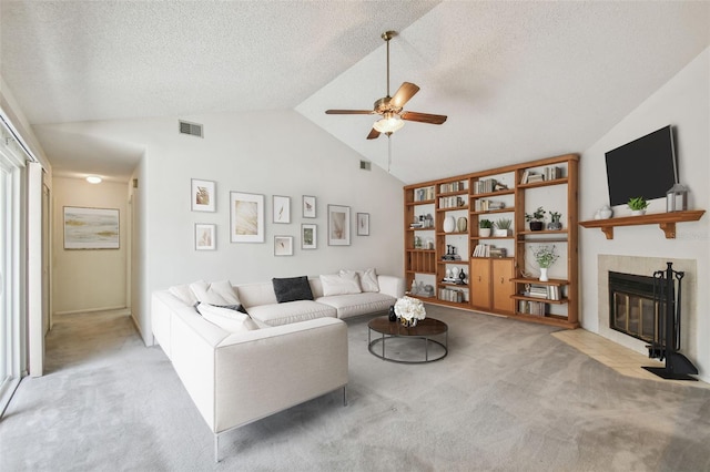 7035 Drury St, Tampa, FL 33635 - living room with light colored carpet, lofted ceiling, ceiling fan, a tiled fireplace, and a textured ceiling