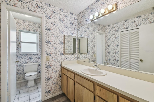 7035 Drury St, Tampa, FL 33635 - bathroom featuring a textured ceiling, vanity, toilet, wallpapered walls, and baseboards