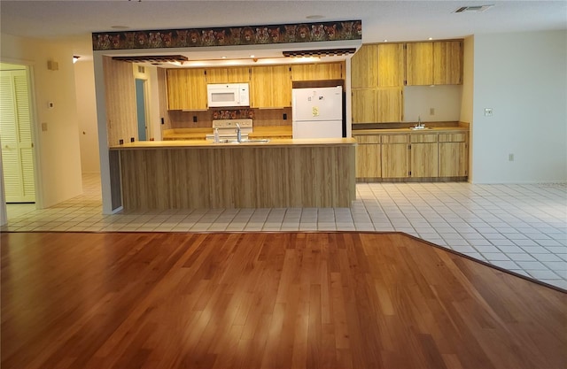 50 Water Oak Way, Oldsmar, FL 34677 - kitchen featuring white appliances, a sink, a peninsula, and light tile patterned floors