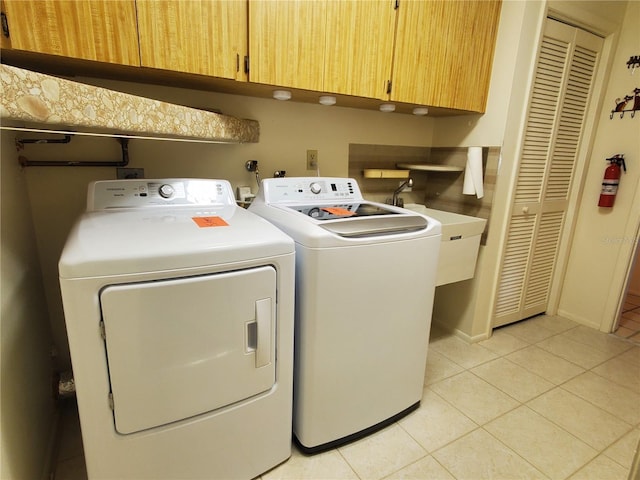 50 Water Oak Way, Oldsmar, FL 34677 - washroom with cabinet space, washer and clothes dryer, light tile patterned floors, and baseboards