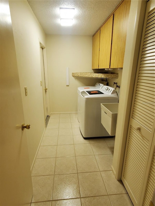 50 Water Oak Way, Oldsmar, FL 34677 - washroom featuring cabinet space, washing machine and clothes dryer, a textured ceiling, light tile patterned floors, and baseboards