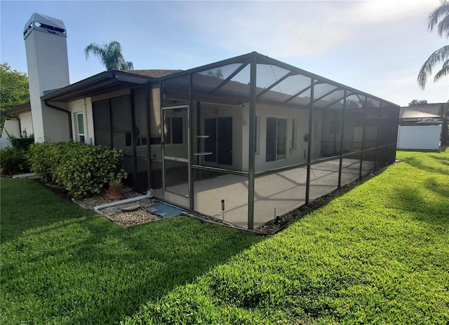 50 Water Oak Way, Oldsmar, FL 34677 - back of house featuring a chimney, a lawn, a patio area, a lanai, and stucco siding