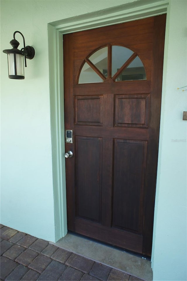 doorway to property featuring stucco siding