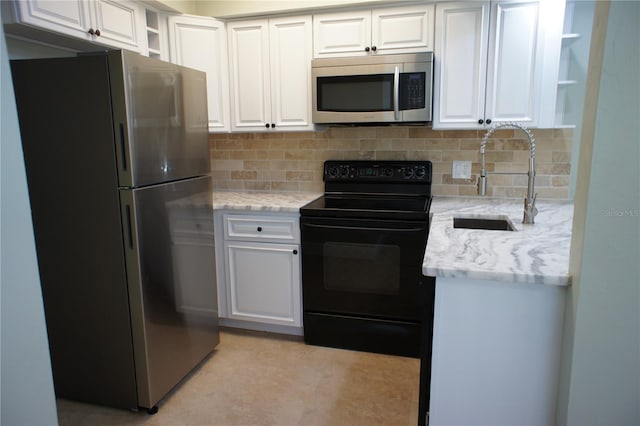 kitchen with appliances with stainless steel finishes, open shelves, a sink, white cabinets, and decorative backsplash