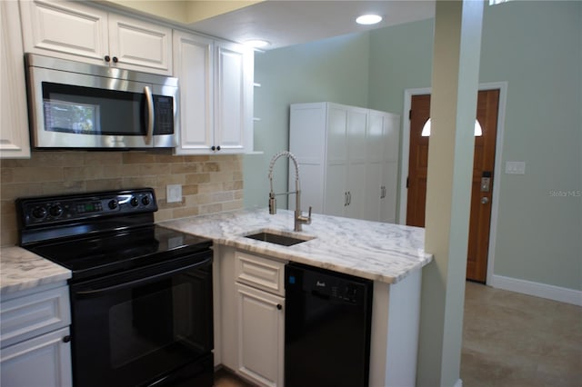 kitchen featuring black appliances, a sink, white cabinetry, decorative backsplash, and light stone counters