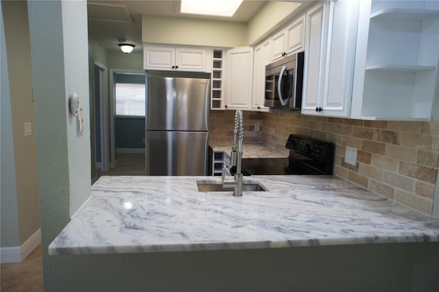 kitchen featuring open shelves, appliances with stainless steel finishes, tasteful backsplash, light stone countertops, and white cabinets