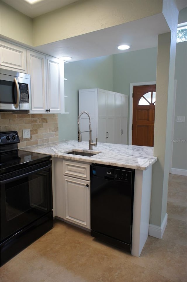 kitchen with black appliances, a sink, a peninsula, white cabinetry, and tasteful backsplash
