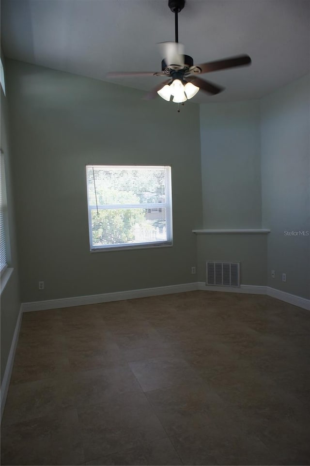 empty room with a ceiling fan and baseboards