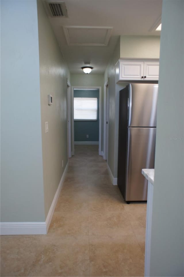 hallway featuring baseboards and attic access