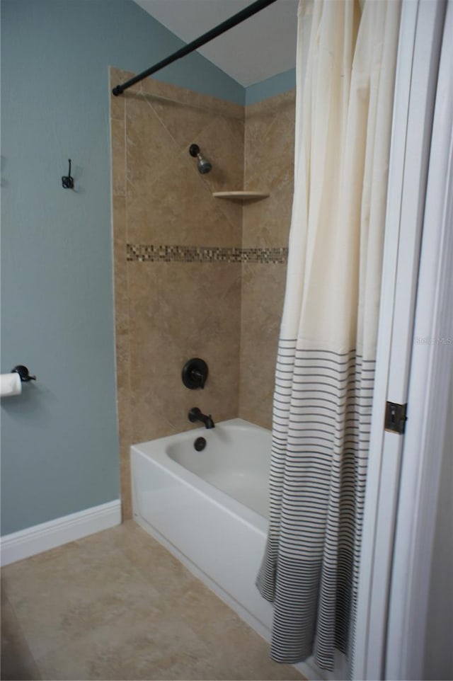 bathroom with shower / bath combo with shower curtain, tile patterned flooring, and baseboards