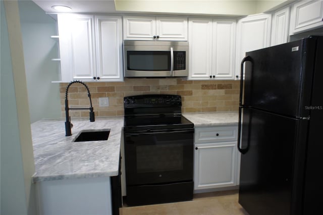 kitchen with black appliances, tasteful backsplash, and white cabinets
