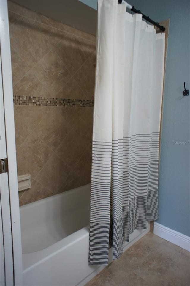 full bathroom with shower / bath combo with shower curtain and baseboards