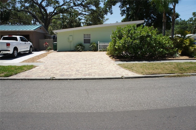 view of front facade with driveway and fence