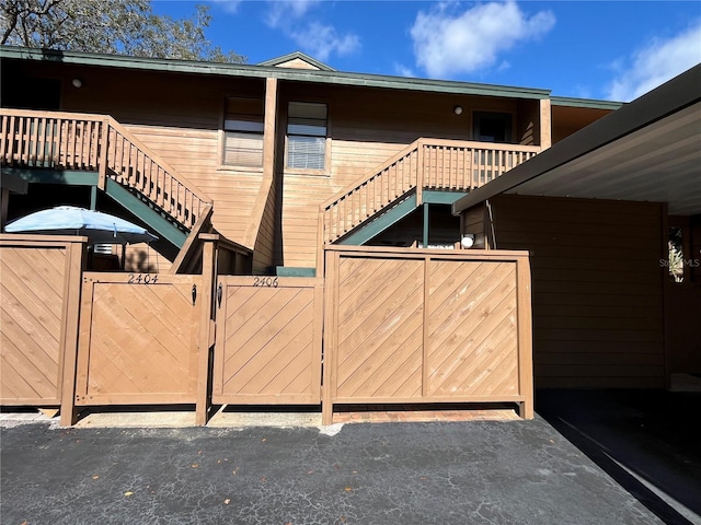 2406 Cypress Pond Rd Unit 2406, Palm Harbor, FL 34683 - view of side of property featuring a gate, fence, and stairs