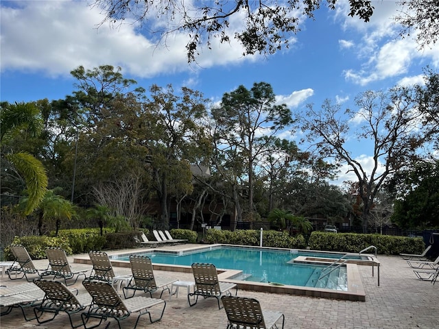 2406 Cypress Pond Rd Unit 2406, Palm Harbor, FL 34683 - community pool with a hot tub, a patio area, fence, and view of scattered trees