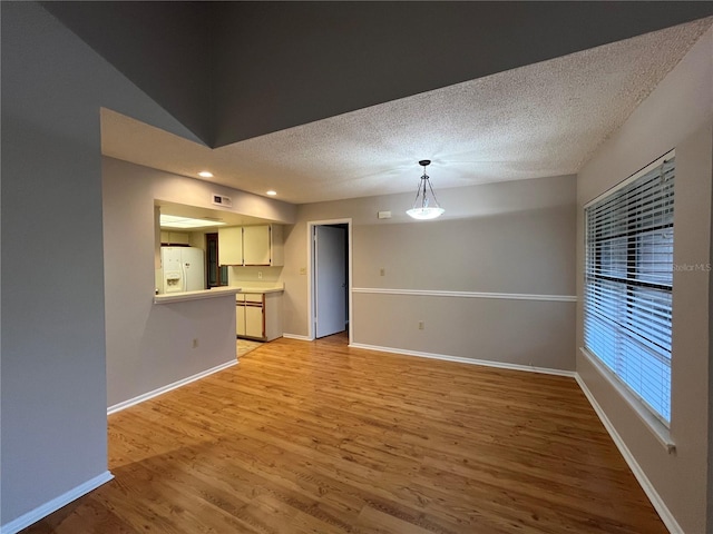 2406 Cypress Pond Rd Unit 2406, Palm Harbor, FL 34683 - unfurnished living room with light wood finished floors, a textured ceiling, and baseboards