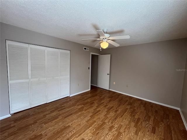 2406 Cypress Pond Rd Unit 2406, Palm Harbor, FL 34683 - unfurnished bedroom with wood finished floors, a closet, baseboards, and a textured ceiling