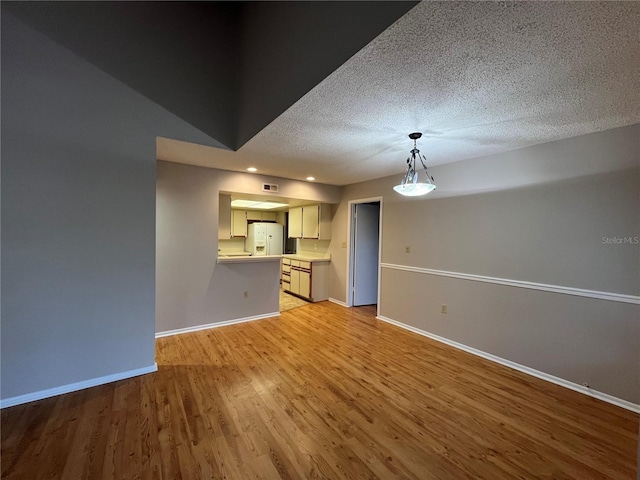 2406 Cypress Pond Rd Unit 2406, Palm Harbor, FL 34683 - unfurnished living room with baseboards, light wood-style flooring, and a textured ceiling