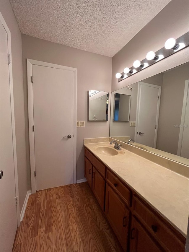 2406 Cypress Pond Rd Unit 2406, Palm Harbor, FL 34683 - bathroom featuring wood finished floors, a textured ceiling, and vanity