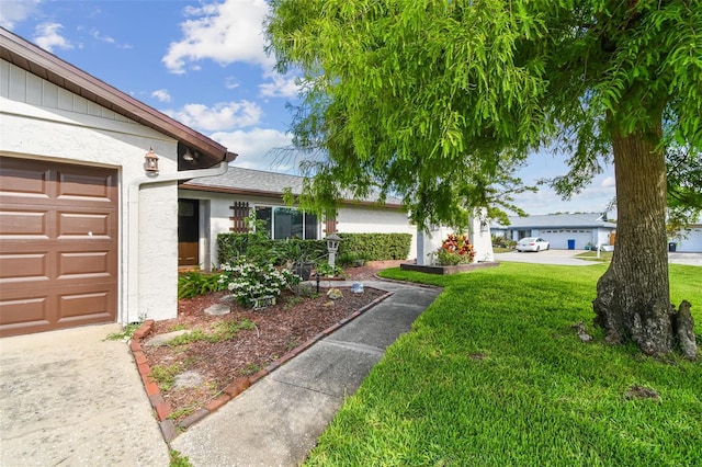 view of green lawn featuring a garage