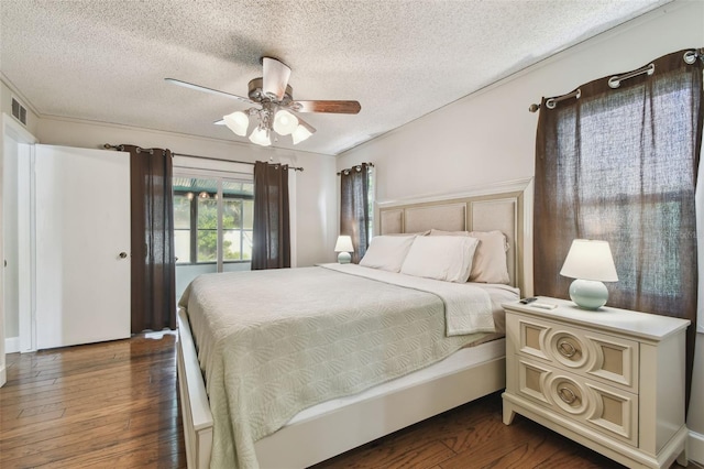 bedroom featuring a textured ceiling, a ceiling fan, and dark wood finished floors