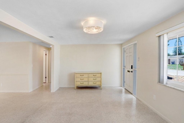 3247 Kimberly Oaks Dr, Holiday, FL 34691 - unfurnished room with plenty of natural light, baseboards, and speckled floor