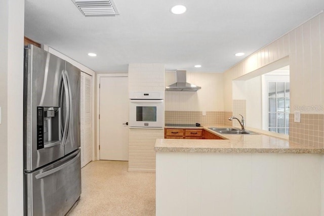 3247 Kimberly Oaks Dr, Holiday, FL 34691 - kitchen with stainless steel refrigerator with ice dispenser, oven, wall chimney range hood, a sink, and backsplash