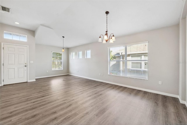 foyer entrance featuring a chandelier, baseboards, and wood finished floors