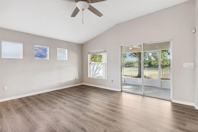 spare room featuring ceiling fan, vaulted ceiling, wood finished floors, and baseboards