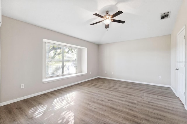 unfurnished room featuring ceiling fan, wood finished floors, baseboards, and vaulted ceiling
