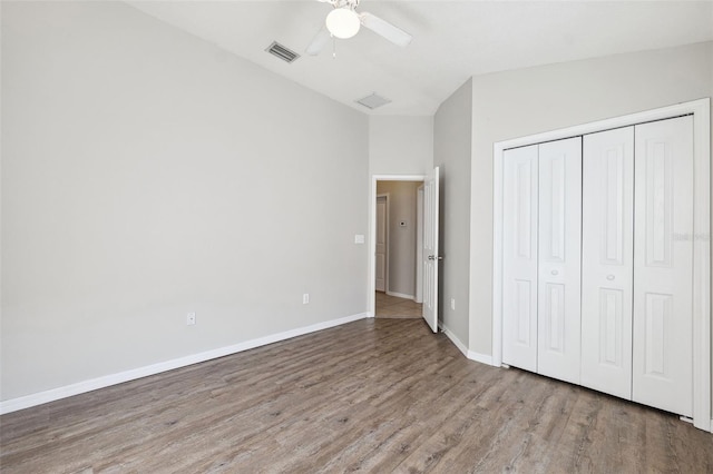 unfurnished bedroom with wood finished floors, baseboards, a closet, and a ceiling fan