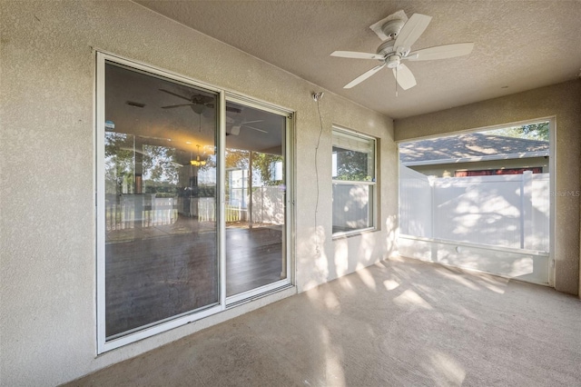 unfurnished sunroom featuring ceiling fan