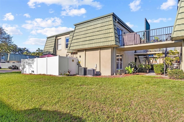 1799 N Highland Ave Unit 180, Clearwater, FL 33755 - rear view of house featuring stairway, mansard roof, stucco siding, and a wooden deck
