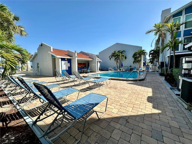320 Medallion Blvd Unit G, Madeira Beach, FL 33708 - community pool with a patio, central AC unit, and fence
