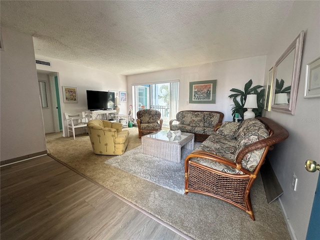 320 Medallion Blvd Unit G, Madeira Beach, FL 33708 - living room with wood finished floors, a textured ceiling, and baseboards