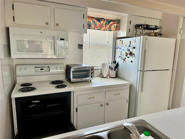320 Medallion Blvd Unit G, Madeira Beach, FL 33708 - kitchen featuring white appliances, light countertops, white cabinetry, and a sink