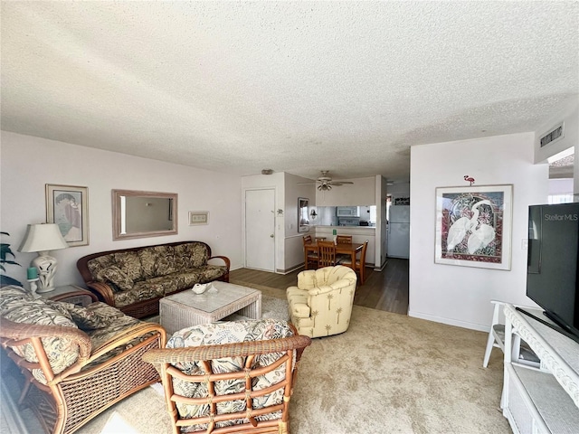 320 Medallion Blvd Unit G, Madeira Beach, FL 33708 - living room with a textured ceiling, a ceiling fan, carpet floors, and wood finished floors