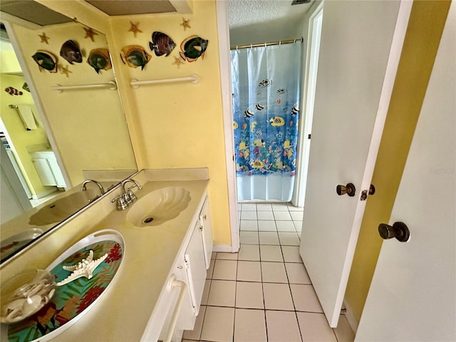 320 Medallion Blvd Unit G, Madeira Beach, FL 33708 - bathroom featuring tile patterned floors, baseboards, vanity, curtained shower, and a textured ceiling