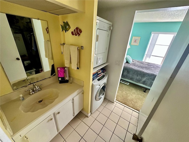 320 Medallion Blvd Unit G, Madeira Beach, FL 33708 - bathroom featuring estacked washer and dryer, tile patterned floors, vanity, and a textured ceiling