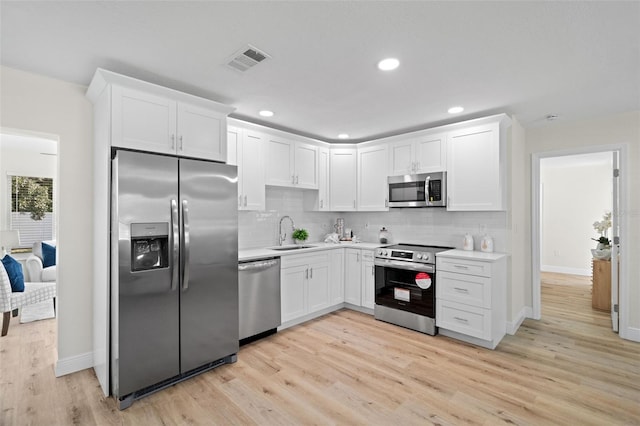 4549 Ontario Dr, New Port Richey, FL 34652 - kitchen featuring appliances with stainless steel finishes, a sink, white cabinets, light countertops, and recessed lighting