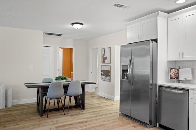 4549 Ontario Dr, New Port Richey, FL 34652 - kitchen featuring appliances with stainless steel finishes, baseboards, light wood-style flooring, white cabinets, and light countertops