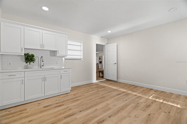 4549 Ontario Dr, New Port Richey, FL 34652 - kitchen with a sink, baseboards, light countertops, white cabinets, and tasteful backsplash