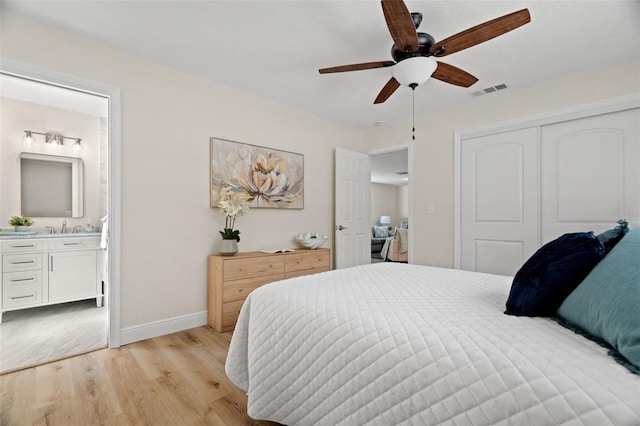 4549 Ontario Dr, New Port Richey, FL 34652 - bedroom featuring light wood-type flooring, a closet, baseboards, ensuite bathroom, and a sink