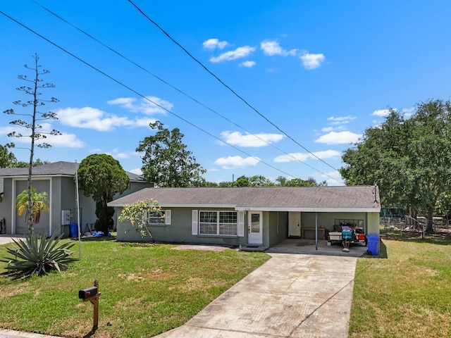 single story home with an attached carport, a front yard, and driveway