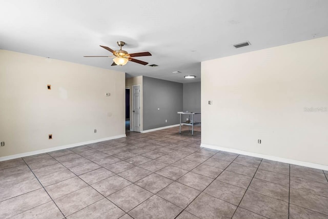 unfurnished room with ceiling fan, tile patterned floors, and baseboards
