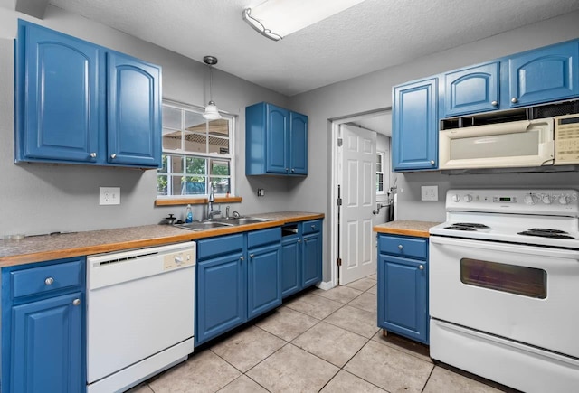 kitchen featuring white appliances, blue cabinets, a sink, light tile patterned floors, and a textured ceiling