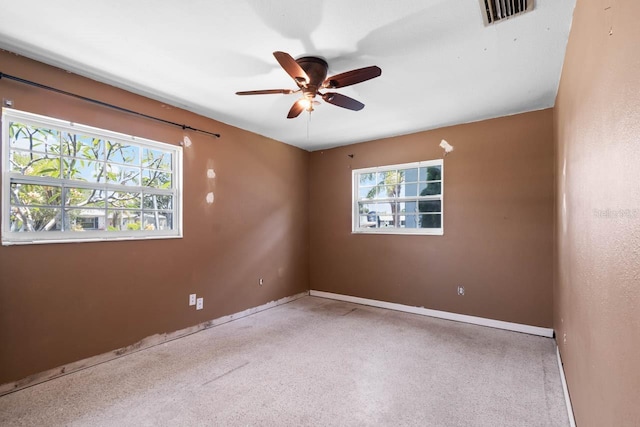 unfurnished room with plenty of natural light, a ceiling fan, and baseboards