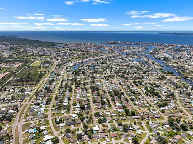 aerial view of property's location featuring a nearby body of water and nearby suburban area